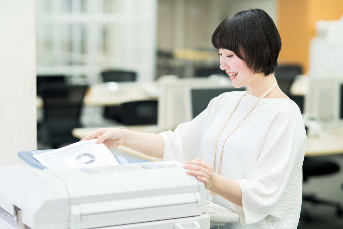 オフィスでシャープ製の中古複合機を使う社員